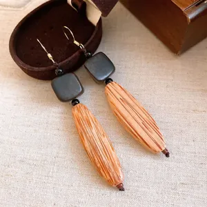 Nahaufnahme von Vintage-Holzohrringen mit natürlicher Maserung und Quadraten