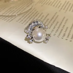 Detailaufnahme eines eleganten Perlenblumenrings mit silberfarbenen floralen Akzenten