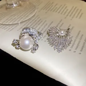 Makroaufnahme von luxuriösen Perlen- und kristallfächerförmigen Ringen auf Buchseiten.