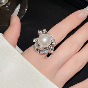 Detailaufnahme eines luxuriösen Perlenblumenrings am Finger für elegante Damen