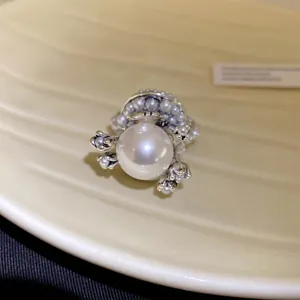 Detailaufnahme eines silbernen Vintage-Blumenrings mit einer großen weißen Perle