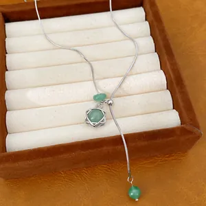 Detailansicht einer silbernen Edelstahl-Halskette mit grünen Steinperlen