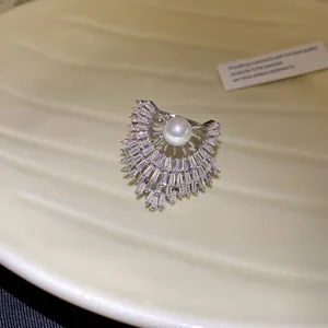 Detailansicht eines luxuriösen fächerförmigen Rings mit einer Perle und glänzenden Kristallen