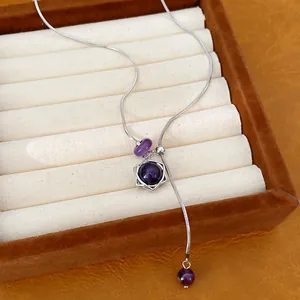 Detailansicht einer Halskette aus Edelstahl mit Hexagramm und lila Kristallperlen.