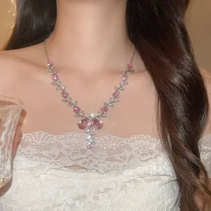 Détail d'un collier élégant avec fleurs roses et feuilles en strass porté par un modèle
