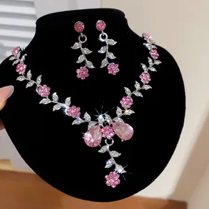 Gros plan détaillé sur un ensemble collier et boucles d'oreilles en cristal rose