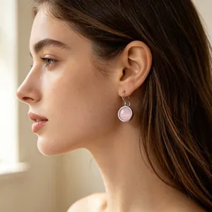 Close-up view of elegant pink round zircon drop earrings on a female model profile
