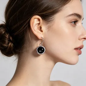 Close-up of a model wearing a stylish round black zircon earring in polished stainless steel
