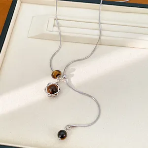Minimalistische Edelstahl Y-Halskette mit Tigerauge-Perlen und Sternanhänger Detail.