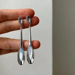 Détail de boucles d'oreilles pendantes minimalistes avec pierres œil-de-chat