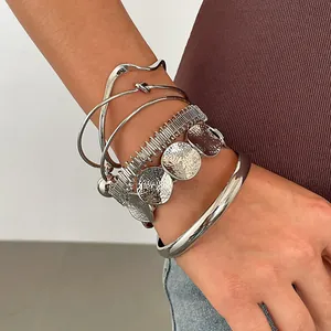 Detailweergave van de zesdelige zilveren geometrische armbandset met gehamerde texturen