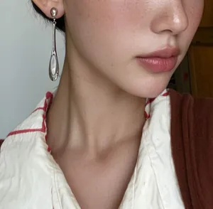 Vue détaillée d'une boucle d'oreille goutte en argent avec incrustation d'oeil de chat