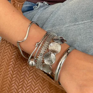 Gedetailleerd overzicht van een zesdelige set zilveren onregelmatige geometrische armbanden