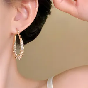Detail view of elegant gold waterdrop hoop earrings with micro-set sparkling stones.