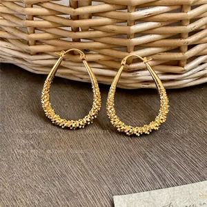 Detailed view of elegant gold teardrop hoop earrings with unique textured finish