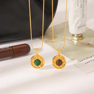 Detailed close-up of vintage sunburst round pendants with green and brown natural stones.