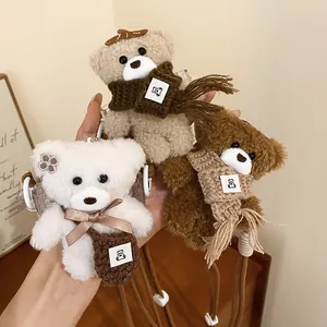 Three cute plush bear pendants featuring scarves and bags on brown adjustable cord necklaces.