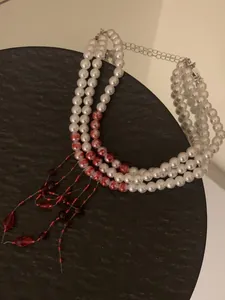 Close-up van een drielaagse Halloween-parelketting met kralen met rood bloedspat-effect