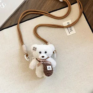 Close-up of cute white plush bear pendant necklace with brown knitted bag detail