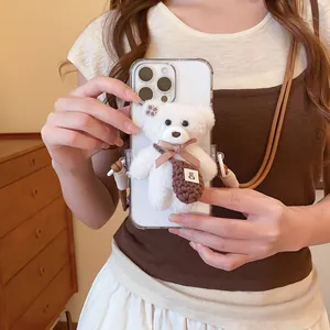 Close-up of a cute white plush bear accessory attached to a mobile phone case.