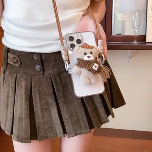 Detail view of a cute plush bear accessory on a transparent phone case with a strap