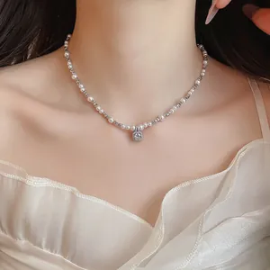 Close-up of elegant pearl and zircon necklace on model's neck for a luxury look