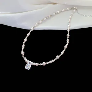 Macro detail view of elegant sparkling cubic zirconia pendant on a lustrous pearl necklace