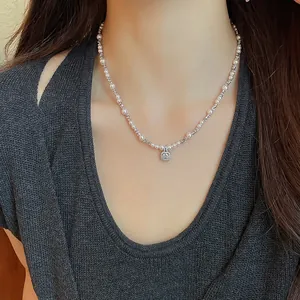 Close-up detail of an elegant pearl necklace with a sparkling square zirconia pendant