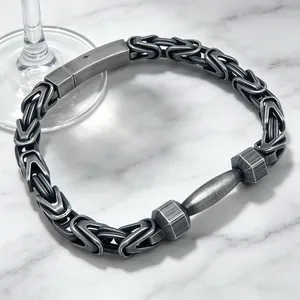 Nahaufnahme eines Herren-Byzantiner-Armbands aus Edelstahl mit Hantel-Anhänger-Detail