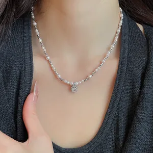 Detailed shot of sparkling zircon and pearl clavicle chain worn on neck for women.