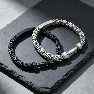 Nahaufnahme von schwarzen und silbernen Byzantine-Armbändern mit Hantel-Anhängern