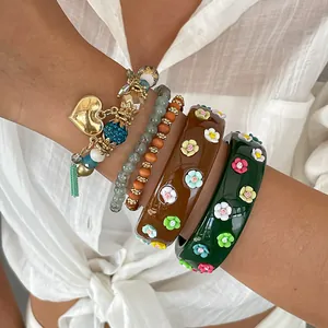 Detailed view of stacked vintage resin bangles with 3D flowers and heart charms