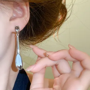 Nahaufnahme eines eleganten silbernen Ohrhängers im koreanischen Stil mit Katzenauge-Stein