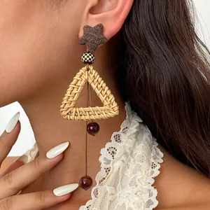 Detailed macro view of vintage rattan woven triangle earrings with dark red glass bead tassels