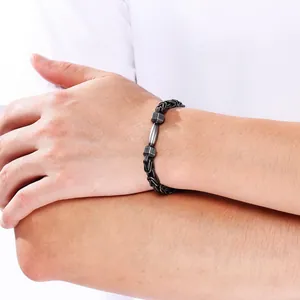 Detail eines schwarzen Edelstahl-Byzanz-Armbandes mit Hantel-Anhänger an einem Handgelenk.
