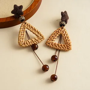 Exquisite macro detail of retro rattan woven triangle earrings with amber glass beads