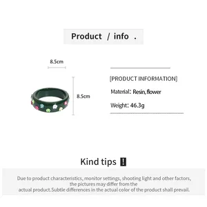 Detail view of green resin floral bangle with material and weight specifications