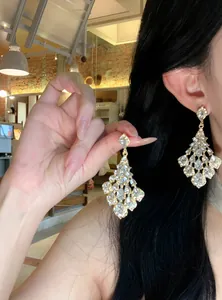 Close-up of retro palace style teardrop diamond dangle earrings on an Asian model