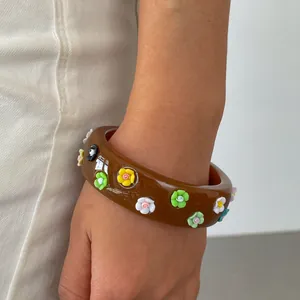 Detailed close-up view of a retro brown resin bangle featuring colorful 3D flower decorations