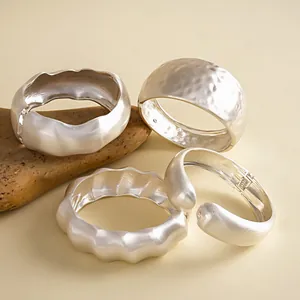 Detailed view of silver metallic bangles with hammered and wrinkled textures