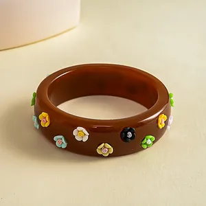 Detailed view of a vintage brown resin bangle with colorful 3D flower embellishments