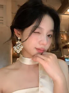 Close-up detail of vintage palace style rhinestone chandelier drop earrings on an Asian model