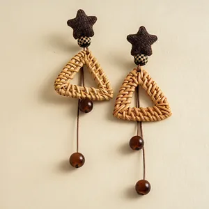 Detailed close-up of vintage rattan triangle earrings with plush stars and glass beads