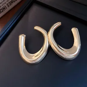 Macro-opname van gouden U-vormige oorbellen met een hoogglanzende gepolijste afwerking