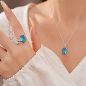Close-up detail of silver-colored jewelry set featuring oval blue zircon gems