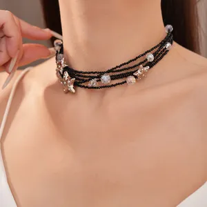 Close-up van meerlaagse zwarte kralen choker met kristallen sterren op een modelhals