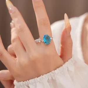 Detailed close-up of an elegant fashion ring with a large oval blue zircon gemstone