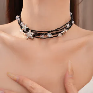 Gedetailleerde weergave van een meerlaagse zwarte kralenketting met kristallen sterren