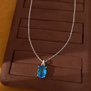 Detail shot of elegant oval blue zircon pendant on a delicate silver-tone necklace chain