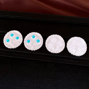Detailansicht von runden Silberohrringen im Vintage-Stil mit Harzblumen in Türkis und Perle